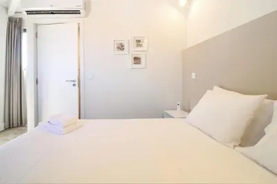 a white bedroom with a large white bed at Msc Flats in Porto