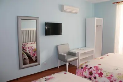 a bedroom with a mirror and a chair and a bed at Grande Oceano Guest House in Porto