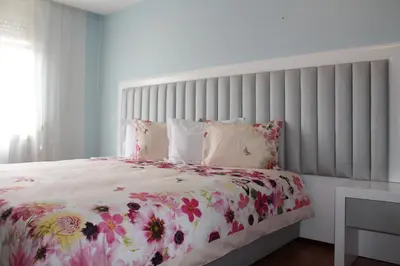 a bedroom with a large bed with a floral bedspread at Grande Oceano Guest House in Porto