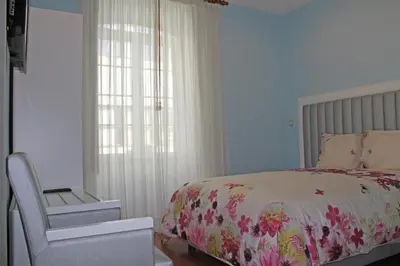a bedroom with a bed and a chair and a window at Grande Oceano Guest House in Porto