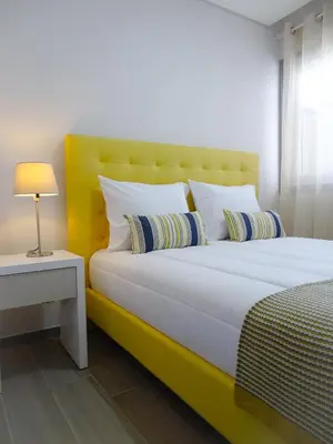 a bedroom with a large bed with a yellow headboard at RS Porto Apartments in Porto