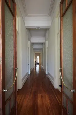 an empty hallway in an old building with wooden floors at The Passenger Hostel in Porto