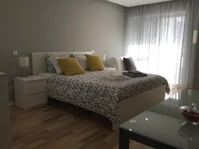 a bedroom with a bed with yellow pillows and a window at Oporto Bernardes Studios - Heroísmo in Porto