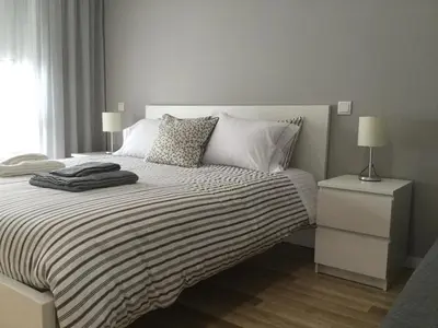 a bedroom with a bed with a black and white comforter at Oporto Bernardes Studios - Heroísmo in Porto