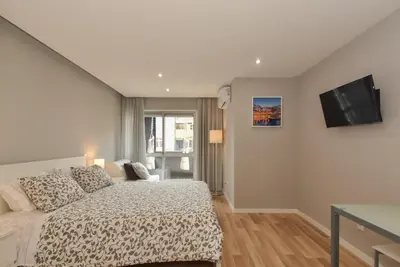 a bedroom with a bed and a flat screen tv at Oporto Bernardes Studios - Heroísmo in Porto