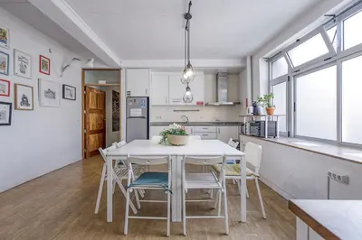 a kitchen and dining room with a white table and chairs at Travel & Live Hostel in Porto