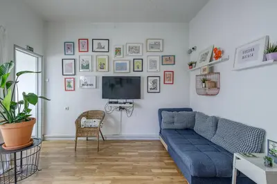 a living room with a blue couch and a tv at Travel & Live Hostel in Porto