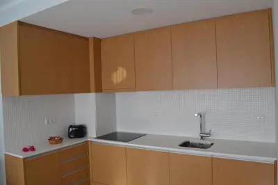 a kitchen with wooden cabinets and a sink at RockInn Porto in Vila Nova de Gaia