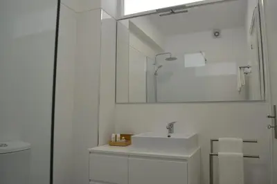 a white bathroom with a sink and a mirror at RockInn Porto in Vila Nova de Gaia