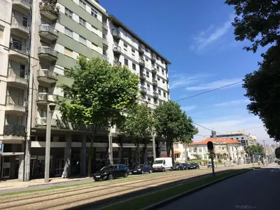 a street with cars parked in front of a building at RockInn Porto in Vila Nova de Gaia