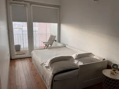 a bedroom with a bed and a balcony with a chair at Go2oporto - Fontainhas Apartments in Porto