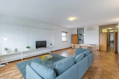 a living room with a blue couch and a table at BEST - Trindade Tower in Porto