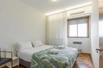a small bedroom with a bed and a window at BEST - Trindade Tower in Porto