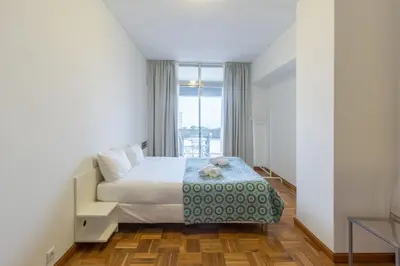 a bedroom with a bed and a large window at BEST - Trindade Tower in Porto