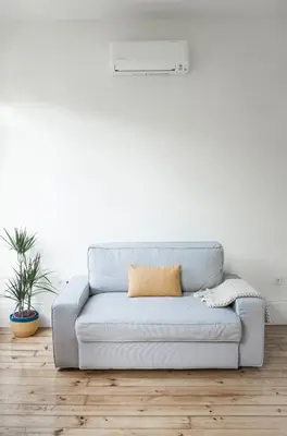 a couch in a living room with a white wall at Zelije Apartments Trindade in Porto