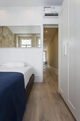 a white bedroom with a bed and a hallway at RVA - Clerigos Apartments in Porto