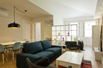 a living room with a blue couch and a table at RVA - Clerigos Apartments in Porto