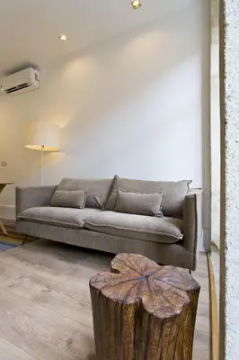 a living room with a couch and a tree stump in the foreground at RVA - Clerigos Apartments in Porto