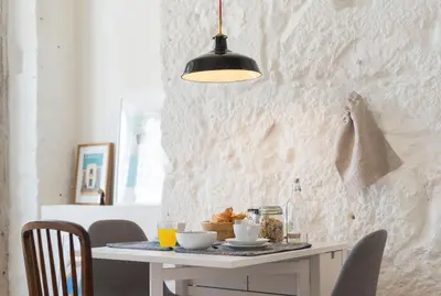 a dining room table with a black pendant light at LovelyStay - Cativo Mezzanine Studio in Porto