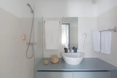 a white bathroom with a sink and a shower at Citybreak-apartments Coliseu in Porto