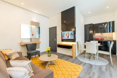 a living room with a couch and a table and a kitchen at LETHESHOME Apartments in Porto