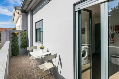 a patio with a table and chairs on a balcony at Apartamento À Francos Balcony in Porto
