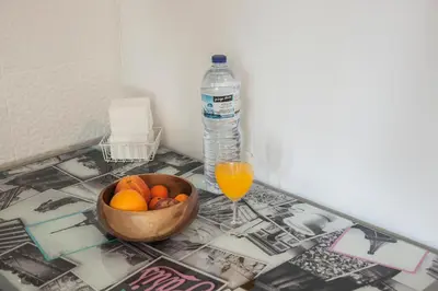 a bowl of oranges and a glass of orange juice and a bottle of water at Apartamento À Francos Attic in Porto