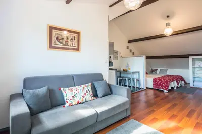 a living room with a couch and a kitchen at Apartamento À Francos Attic in Porto