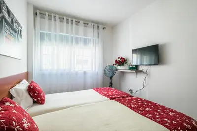 a bedroom with a bed with red pillows and a window at Apartamento À Francos Gyn Lovers in Porto