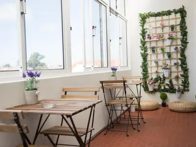 a room with tables and chairs and windows at OPORTO GUEST Cedofeita Terrace in Porto