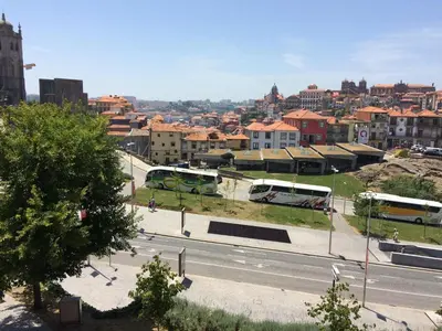 a city with buses parked on the side of a street at Downtown PORTO SE in Porto
