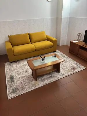 a living room with a yellow couch and a coffee table at Downtown PORTO SE in Porto