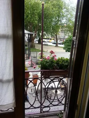 an open door with a balcony with flowers on it at Caldeira Guest House in Porto