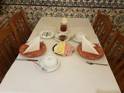 a white table with a candle and plates on it at Caldeira Guest House in Porto