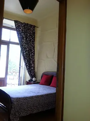 a bedroom with a bed with a window and a bedspread at Caldeira Guest House in Porto