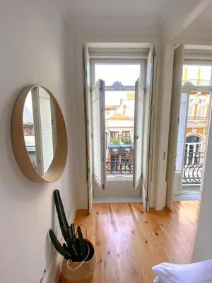 a living room with a mirror and a view of a balcony at CL Ildefonso III Apartment in Porto