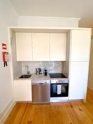 a kitchen with white cabinets and a stainless steel dishwasher at CL Ildefonso III Apartment in Porto