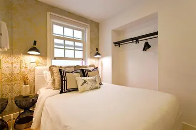 a bedroom with a large white bed with pillows at São Bento Golden Flat in Porto