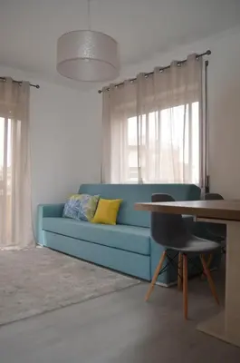 a blue couch in a living room with a table at Modern and Cozy Apartment in Vila Nova de Gaia