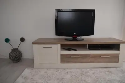 a television sitting on a wooden entertainment center at Modern and Cozy Apartment in Vila Nova de Gaia