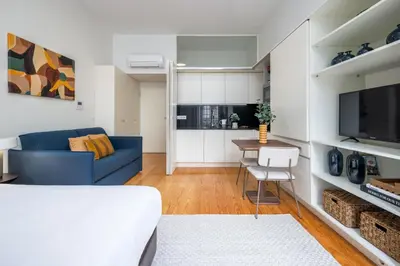 a room with a table and chairs and a bed at Aspasios Trindade Apartments in Porto