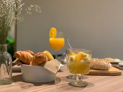 a table with a plate of pastries and a glass of orange juice at Spot Apartments Trindade in Porto