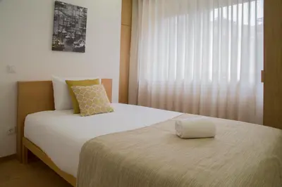 a bedroom with a large white bed with a window at Spot Apartments Trindade in Porto