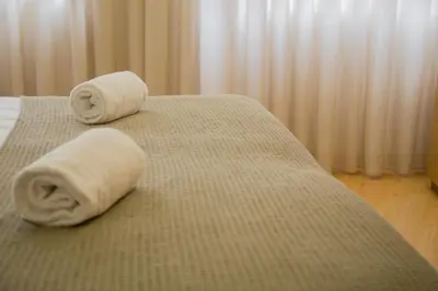 two rolled towels on a bed in a hotel room at Spot Apartments Trindade in Porto