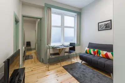 a living room with a couch and a desk at Santa Catarina 652 in Porto