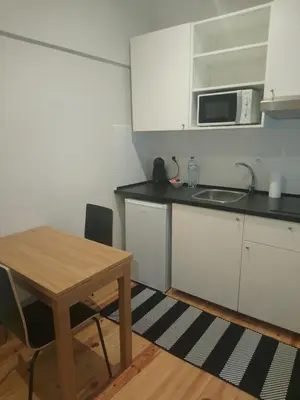 a small kitchen with a table and a microwave at Santa Catarina 652 in Porto