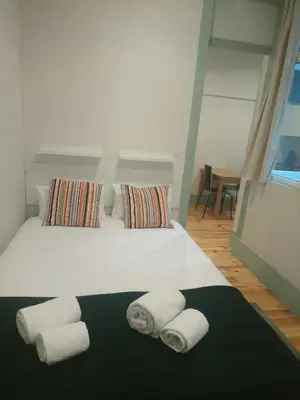 a bedroom with a white bed with towels on it at Santa Catarina 652 in Porto