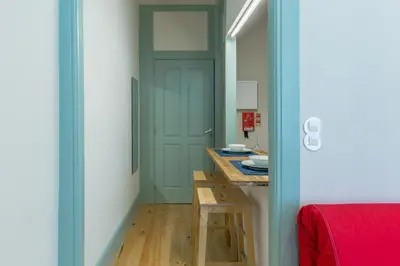 a room with a door and a table with a red blanket at Santa Catarina 652 in Porto