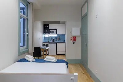 a small room with two beds and a kitchen at Santa Catarina 652 in Porto