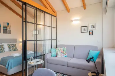 a living room with a couch and a bed at Panoramic luxury apartment w AC Downtown and Metro in Porto